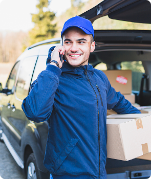 cheerful courier with box talking phone